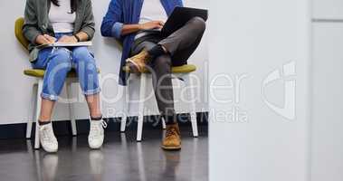 Were all trying to find our place in life. Shot of two unrecognizable people using their devices while waiting to be interviewed in a modern office.