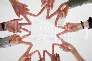 Dont let the mindless clutter your path. Below shot of a group of unrecognizable businesspeople joining their hands against a white background.