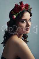 Fantasy and floral, a beautiful combination. Studio shot of a beautiful young woman wearing a floral head wreath against a grey background.