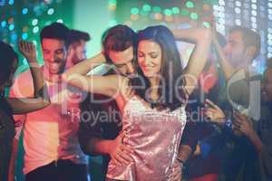 Like no one else is around. Shot of an affectionate young couple dancing on a crowded dance floor in a nightclub.