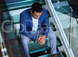 Strength does not come from winning. Shot of a young man sitting on the stairs at work.