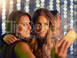 Its been a memorable night out. Shot of two young friends taking selfies while out at a nightclub.