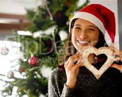 Christmas isnt just a day, its a frame of mind. Shot of a young woman holding Christmas decor at home.