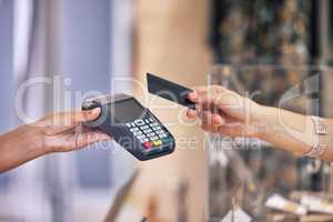 Thank you for shopping with us today. Shot of a woman using her bank card to pay for a purchase in a store.