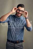 His confidence is clearly noticeable. Studio portrait of a handsome young man posing against a grey background.