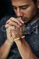 Praying for a miracle. Closeup shot of a young man praying with his eyes closed.