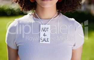 A power than can transform the world. Shot of a unrecognizable woman wearing a sing on her neck in protest outside.