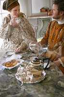 Tea and crumpets. A king and queen taking tea together at home.