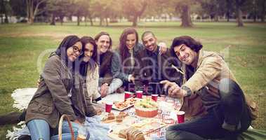 Food, friends, fun and now to capture it. Shot of young friends having a picnic outside.