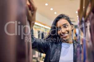 I need an outfit for my date. Shot of a young woman browsing through shopping rails.