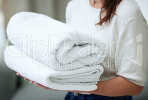 Dunk your face in these. Shot of an unrecognizable woman folding towels at home.