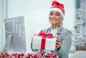 Neatly wrapped Christmas cheer. Portrait of a young beautiful woman spreading Christmas cheer with gifts at the office.