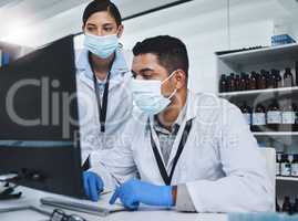 Every contribution brings us closer to our goal. Shot of two young researchers using a computer in a laboratory.