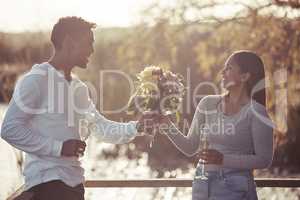 I had to pick flowers that matched your beauty. Shot of a handsome young man giving his girlfriend a bouquet of flowers while on a date outdoors.