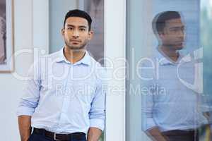 I have big plans for this business. Shot of a handsome young businessman standing alone in the office during the day.