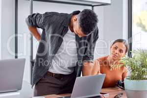 Back pain is so unbearable. Shot of a young businessman in pain in an office.