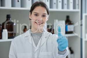 Proving all her theories correct. Portrait of a young scientist showing thumbs up in a lab.