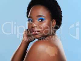 Self acceptance sure is beautiful. Studio shot of a beautiful young woman posing against a blue background.