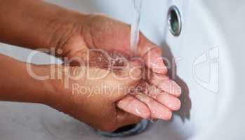 A routine delay, a necessary replay. Cropped shot of an unrecognizable male washing his hands in a hand basin at home.