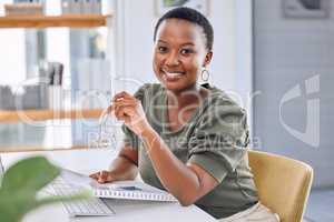 The key to success starts with how you define it. Portrait of a businesswoman smiling while sitting at her desk.