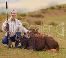 Sharp shooter on the plains. Shot of a female hunter kneeling beside her kill.