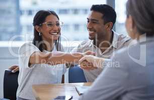 She is the best day of my life. Shot of a young couple sharing a handshake with a consultant theyre meeting to discuss paperwork an office.