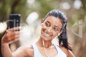 Time to take some snaps for social media. Shot of a young woman using her smartphone to take selfies on her daily jog.