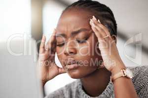 Where did this headache come from. Shot of a young businesswoman looking stressed while using a laptop at her desk in a modern office.