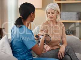 Lets hope my hypertension is under control. Shot of a doctor examining a senior woman with a blood pressure gauge at home.