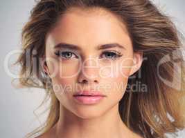 Her beauty is one to behold. Studio portrait of an attractive young woman posing against a grey background.