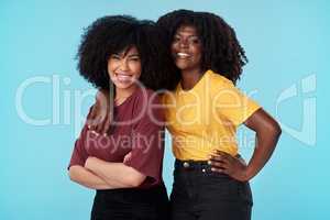 Friends dont let friends stand alone. Studio shot of two young women embracing each other against a blue background.