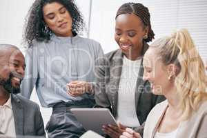 Doing a dry run of her presentation. Cropped shot of a group of white collar businesspeople looking at a tablet during a meeting in the boardroom.