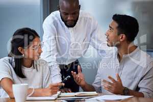 Success on infinite repeat. Shot of diverse group of businesspeople having a quick meeting in an office.