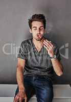 Puffing the pain away. Cropped shot of a beaten and bruised young man smoking a cigarette.