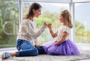 This promise will never be broken. Shot of a young mother and daughter making a pinky promise at home.