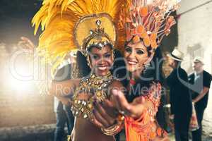 We live to perform. Cropped portrait of two beautiful samba dancers performing at Carnival with their band.