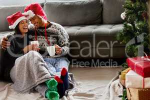 Christmas is a tonic for our souls. Shot of a young couple sitting on the floor at home.