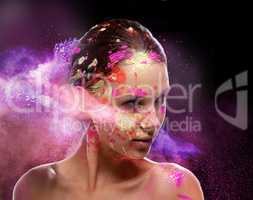 Splash of color. Conceptual shot of a beautiful young woman covered in multi-colored powder paint.