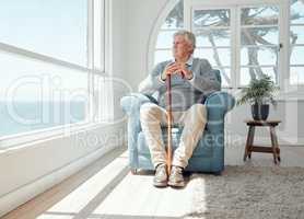 The longing never stops. Shot of an elderly man enjoying the view from his window.