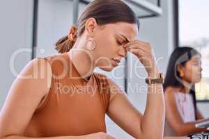 Exams are stressful. Shot of a young businesswoman in pain in an office.