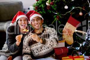 Christmas is the day that holds all time together. Shot of a young couple sitting by their Christmas tree.