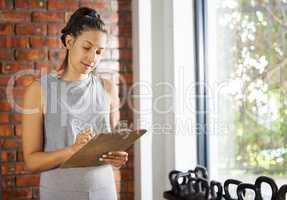 Simplicity is the ultimate sophistication. Shot of a young woman checking the equipment at work in a gym.