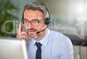 No dreams truly runs cold. Shot of a mature man using a headset and talking to clients while using his computer at work.