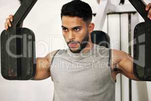 Theres no day that doesnt demand a good workout. Shot of a young man working out with a chest press in a gym.