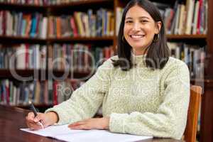 Libraries always remind me that there are good things. Shot of a young woman studying in a college library.