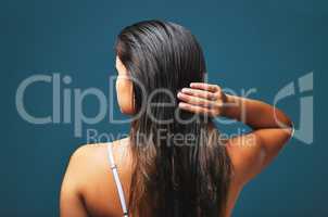 My scars-my best attire. Stunning, my dress of hellfire. Rearview studio shot of a beautiful young woman posing against a blue background.