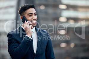 Ill be there shortly. Shot of a handsome young businessman standing alone outside and using his cellphone.