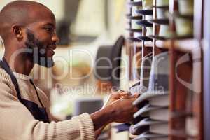 Surround yourself with other supportive businessmen. Shot of a young man working at his job in a shop.