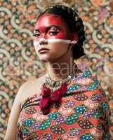 My culture, my identity. Portrait of an attractive young woman dressed in traditional attire and makeup posing against a patterned background.