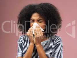 This cold just wont go away. Cropped shot of a young woman blowing her nose into a tissue.